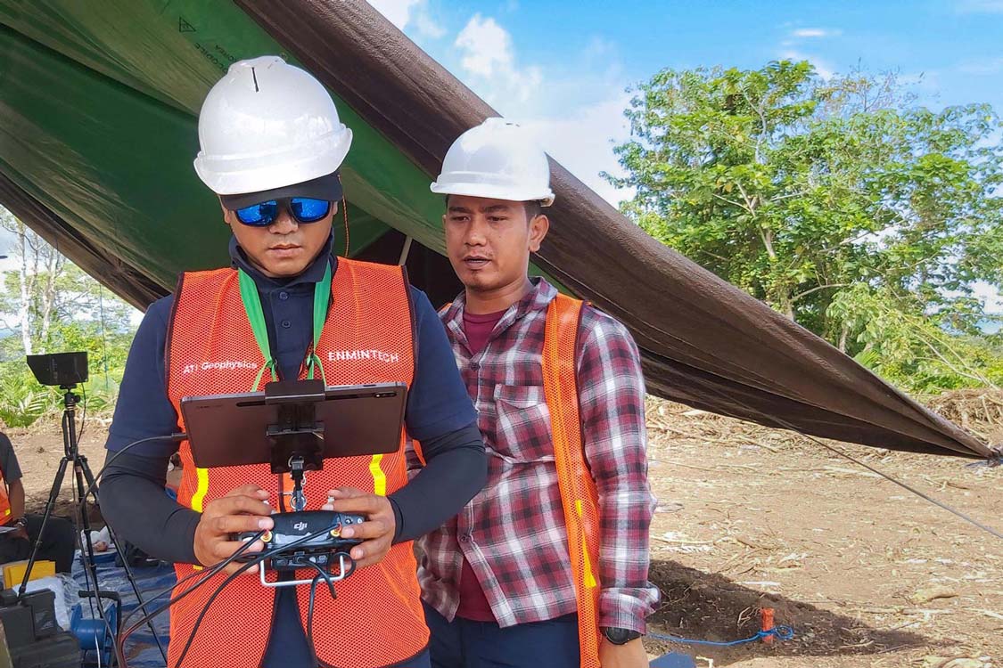 Enmintech Surveyors in Safety Gear conducting UAV Survey for Mineral Exploration in the Field Camp with Drone Controller